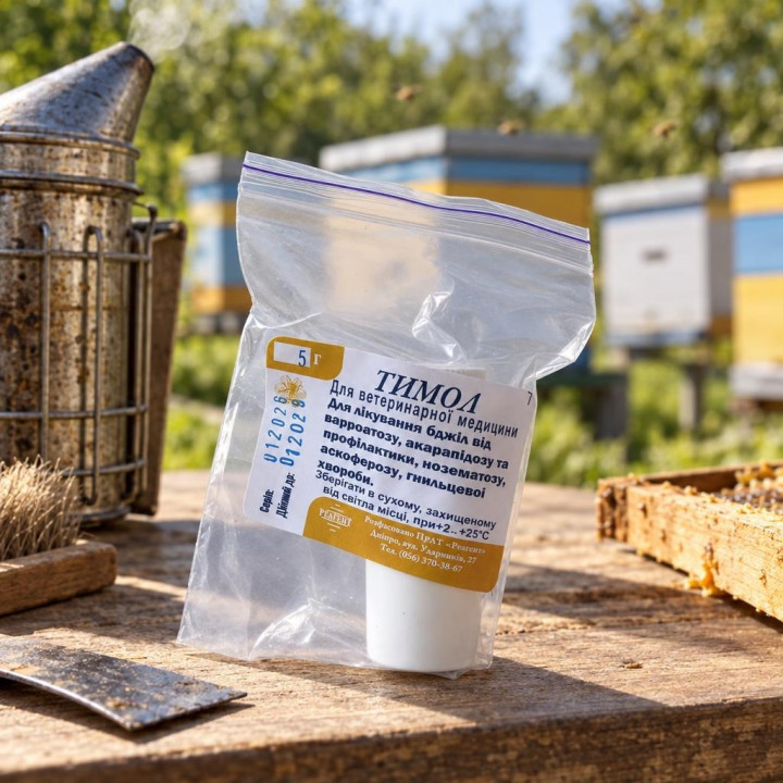 Thymol 5g bag on a wooden table near a smoker and frame at an apiary