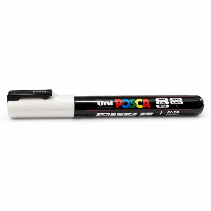 Маркер POSCA з білим ковпачком лежить горизонтально на білому фоні