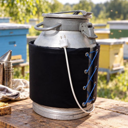 Churn in black wrap with cable on wooden table near beehives outdoors
