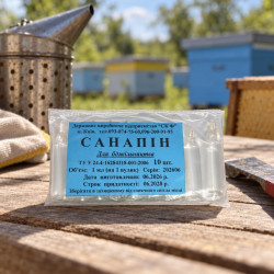 Пакет Санапін 1 мл на дерев’яному столі біля пасічного димаря та вуликів