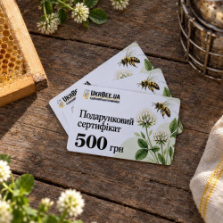 Gift certificates for UAH 500 on a wooden table with honeycomb and clover flowers