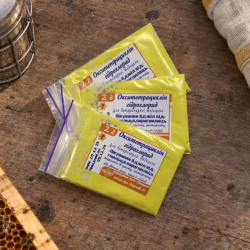 Three yellow Oxytetracycline Hydrochloride 2 g packets in zip bags on a wooden table